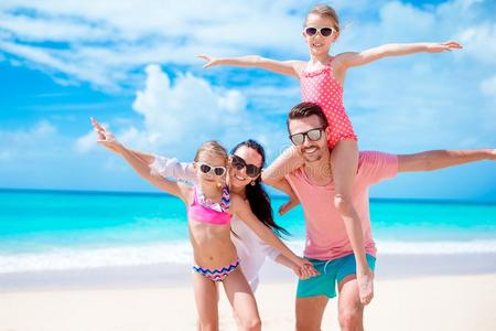 幸福的美丽的家庭向白色的海滩所有乐趣