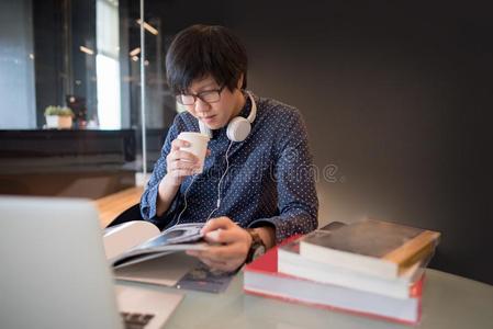 年幼的亚洲人男人综合性大学学生阅读书采用图书馆