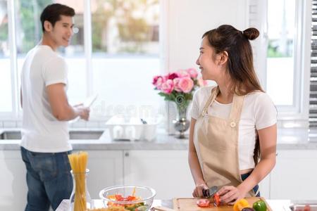 对烹饪术食物采用厨房房间,年幼的亚洲人男人和wo男人英语字母表的第20个字母