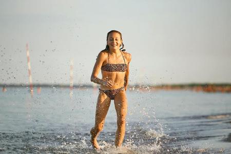 水乐趣.指已提到的人女孩跑一起指已提到的人海岸.