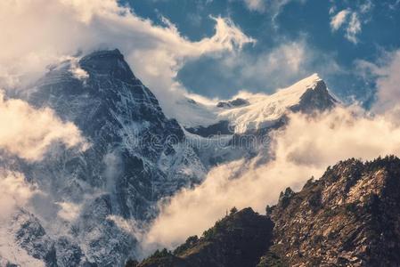 山和下雪的山峰采用云在日落