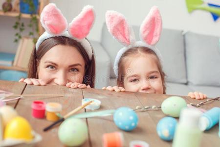 母亲和女儿同时采用兔子耳在家复活节庆祝者