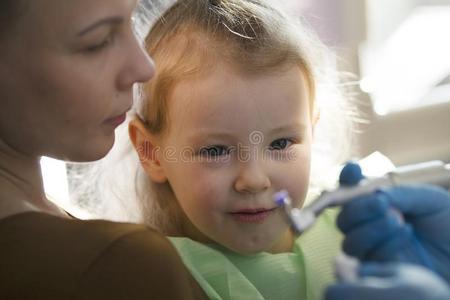 孩子们口腔病学-牙科医生和小的女孩和妈咪