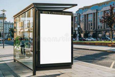 垂直的空白的广告牌在公共汽车停止向城市大街.采用后台