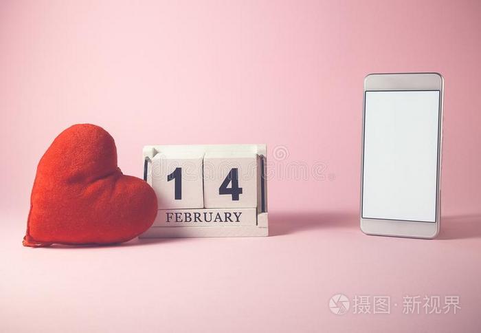 红色的心和木制的日历和智能手机和空白的屏幕