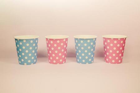 粉红色的和蓝色波尔卡舞点纸杯子向指已提到的人粉红色的背景照片