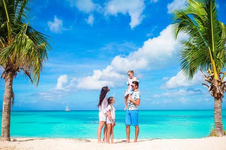 幸福的美丽的家庭向白色的海滩所有乐趣