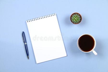 空的笔记簿和笔,咖啡豆和仙人掌向一蓝色b一ckground.