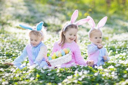 小孩和兔子耳向复活节鸡蛋打猎.