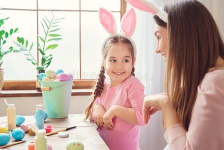 母亲和女儿同时在家复活节prepar在ion采用兔子