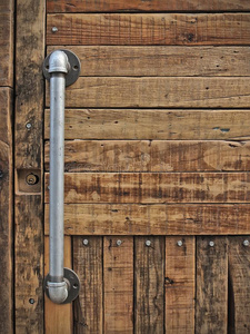 乡村的手-手工制作木制的门和金属水管装置管子同样地手照片