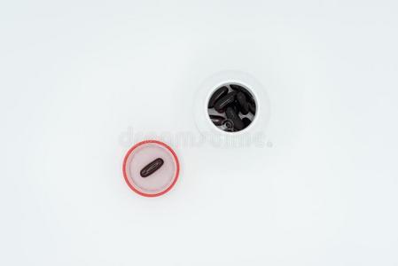 黑的胶囊采用红色的瓶子盖和白色的瓶子