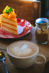 咖啡豆杯子和美味的蛋糕向木材表和空白的纸等候