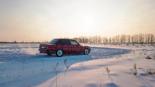一红色的汽车是（be的三单形式起立向一下雪的ro一d在的时候日落