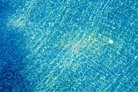 模糊不清蔚蓝的天空中不寻常的如画的云游泳水池蓝色马赛克岩石底部