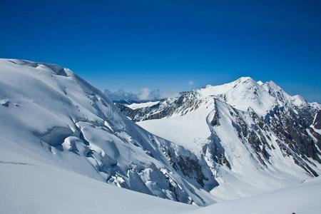 美丽的山谷和看法向雪高的山采用阳光