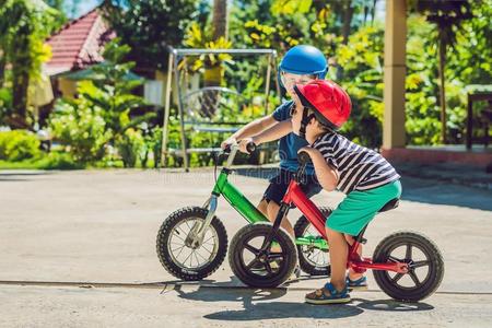 两个小的男孩孩子们所有乐趣向平衡自行车向一国家