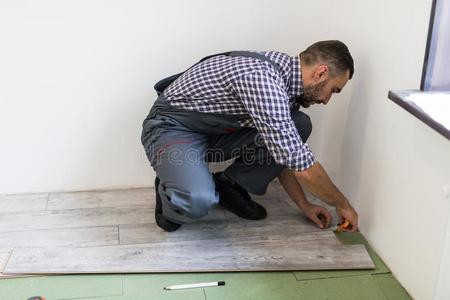 男人工人安装新的木制的制成铺地板采用新的APPRM