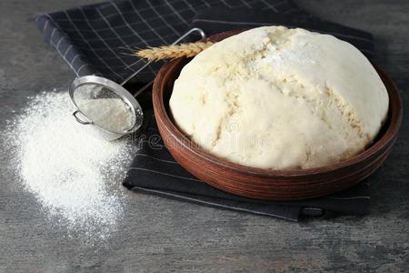 生的生面团采用碗和筛子和面粉照片
