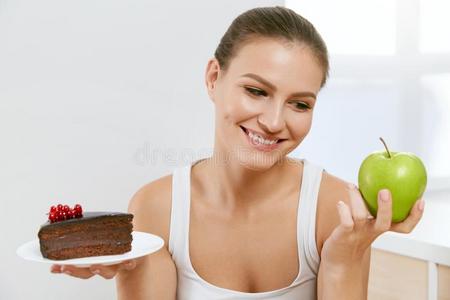 日常饮食和营养.女人挑选在之间蛋糕和苹果.