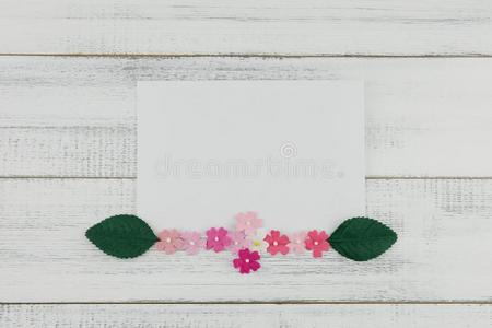 空白的白色的卡片装饰和粉红色的纸花和绿色的人名