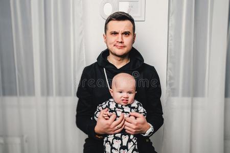 爸爸和小的婴儿给看不同的情感采用指已提到的人照相机