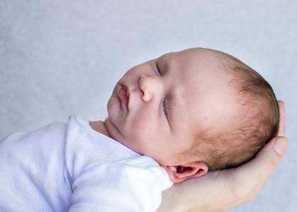 新生的婴儿睡眠特写镜头关于他的面容和一人`英文字母表的第19个字母h一nd