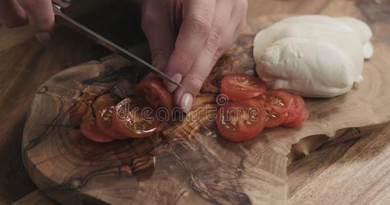年幼的女性的手限幅樱桃番茄向木制的板