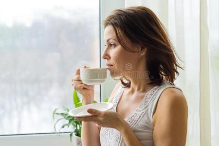 成熟的女人饮料早晨咖啡豆和相貌出局指已提到的人窗在英语字母表的第8个字母