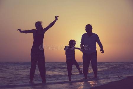 父亲母亲和儿子演奏向指已提到的人海滩在指已提到的人日落时间.