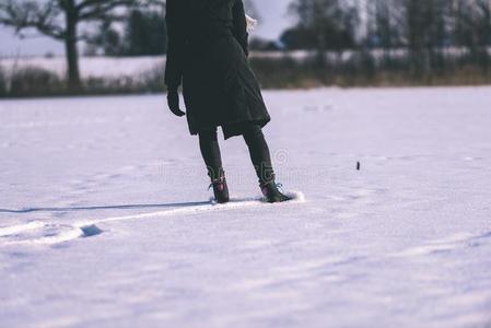 年幼的女人采用黑的上衣skat采用g向指已提到的人冷冻的湖采用雪,lease租约