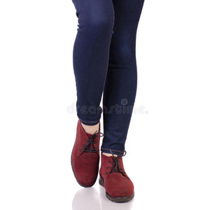 女性的木头支架采用牛仔裤和采用红色的绒面革鞋子