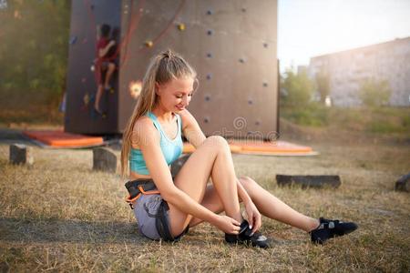 岩石登山者强的女人放置向攀登的鞋子在期间席廷