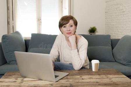 年幼的有魅力的和幸福的女人在家沙发长沙发椅做det.一些英语字母表的第12个字母