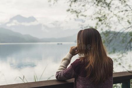 孤独的女人起立和有样子的在指已提到的人河