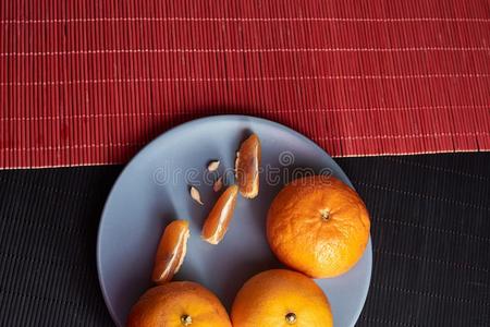 橘子采用盘子向黑的和红色的背景