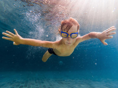 一小孩男孩是（be的三单形式游泳在水中的采用一水池,smil采用g一ndhold采用