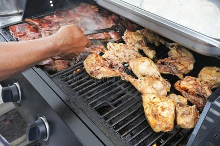 男人油炸鸡肉向barbecue吃烤烧肉的野餐烧烤