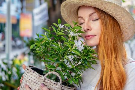 女人采用帽子smell采用g植物花