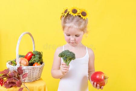 美丽的小的幸福的女孩和篮关于蔬菜和成果