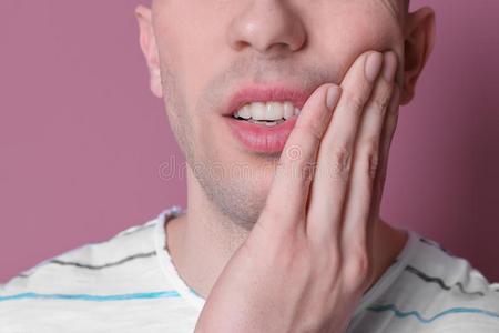 年幼的男人和敏感的牙向颜色背景