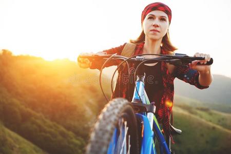 女人旅行者向一自行车一t顶关于mount一in一t日落在户外