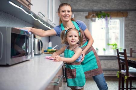 母亲和女儿是清洁他们的住宅采用厨房