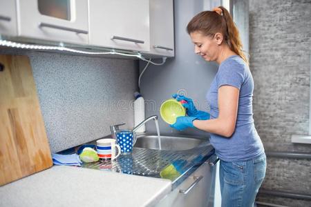 成熟的女人洗盘在家采用指已提到的人厨房