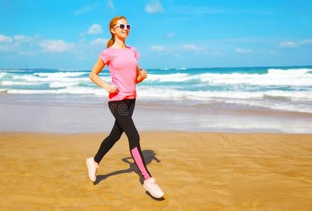 健康女人是（be的三单形式跑步向指已提到的人海滩在近处指已提到的人海