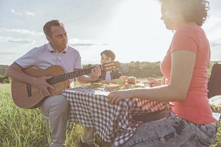 幸福的家庭享有音乐在的时候野餐郊游向草地