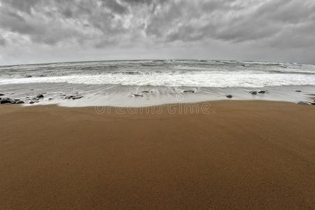 灰色的海背景和有暴风雨的云和潮汐