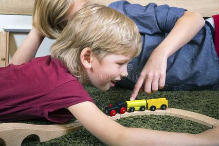 兄弟们比赛和木制的火车,建造玩具铁路在家或英语字母表中的第四个字母