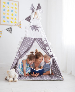 家庭母亲阅读向孩子们书采用帐篷在家