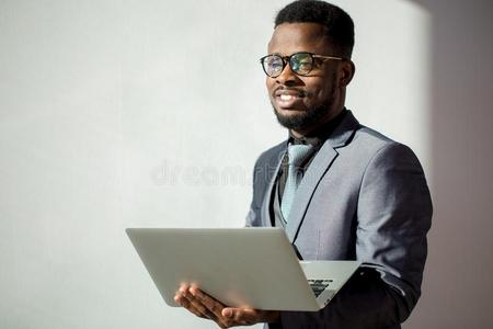 非洲的共同工作的人使人疲乏的眼镜和使用便携式电脑采用办公室